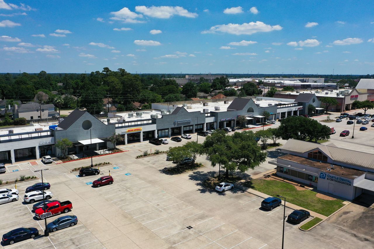 Renovated in-line shops at Deerbrook Shopping Center with the Castle Dental pad in the foreground and Deerbrook Mall on the horizon