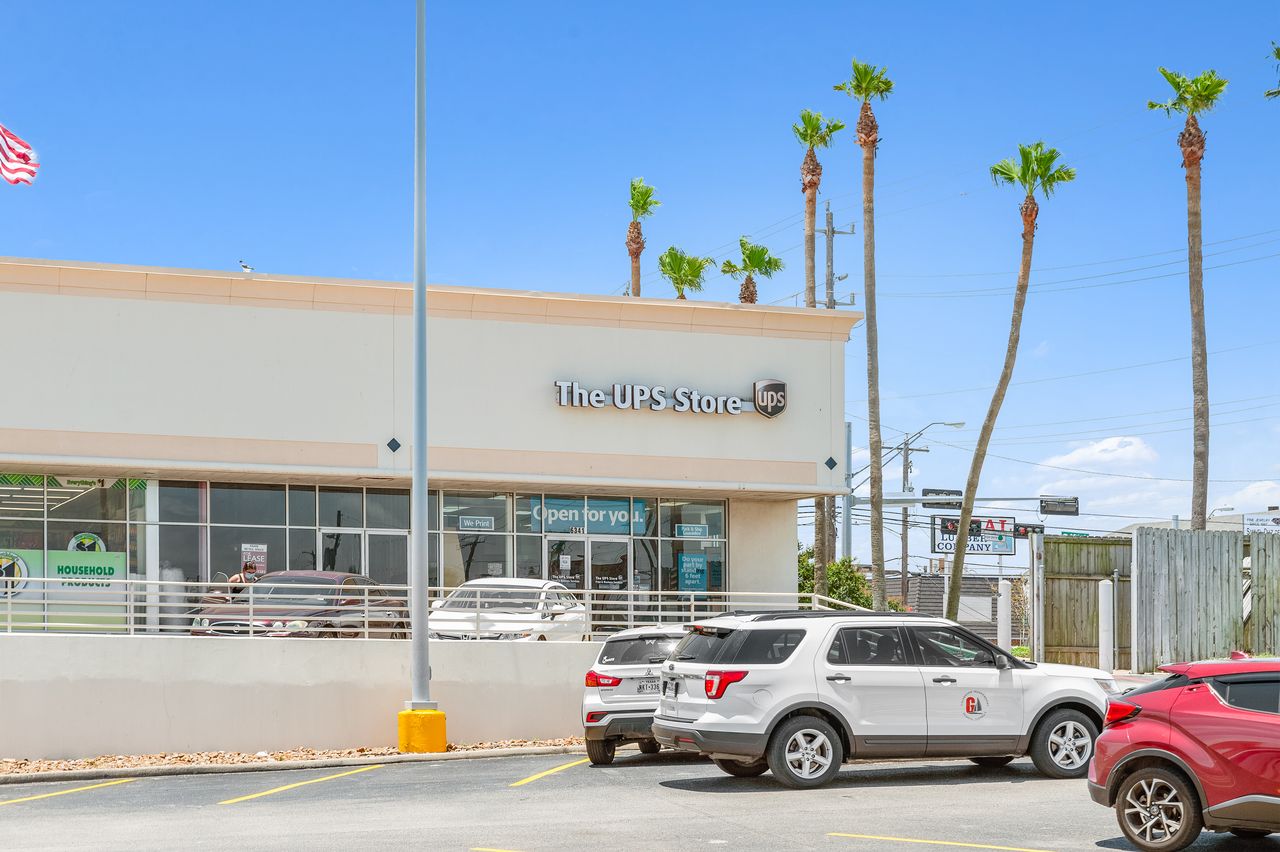 The UPS Store on the west strip at The Plaza on Galveston Island, framed by a row of tall palms