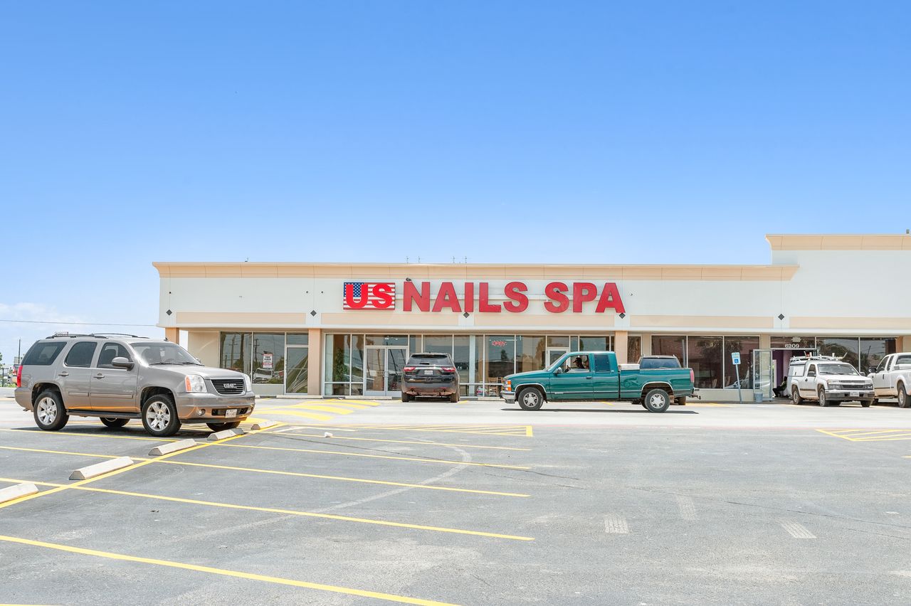 US Nails Spa and the in-line shops strip at The Plaza on Galveston Island with storefront parking