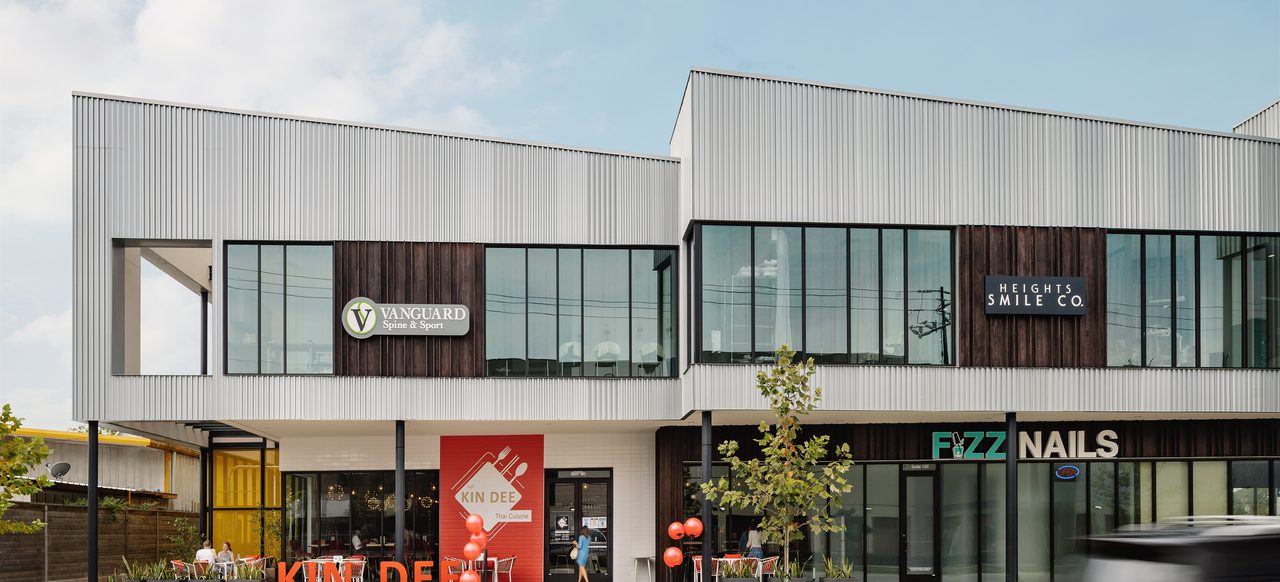 Straight-on view of Market at Houston Heights — Vanguard Spine & Sport and Heights Smile Co. on the second floor above Kin Dee and Fizz Nails at street level